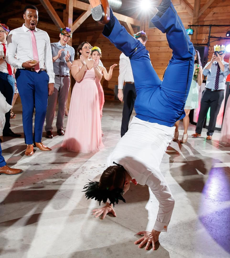 Wedding Guest Dancing A wedding guest performing a handstand on the dancefloor with guests surrounding him.